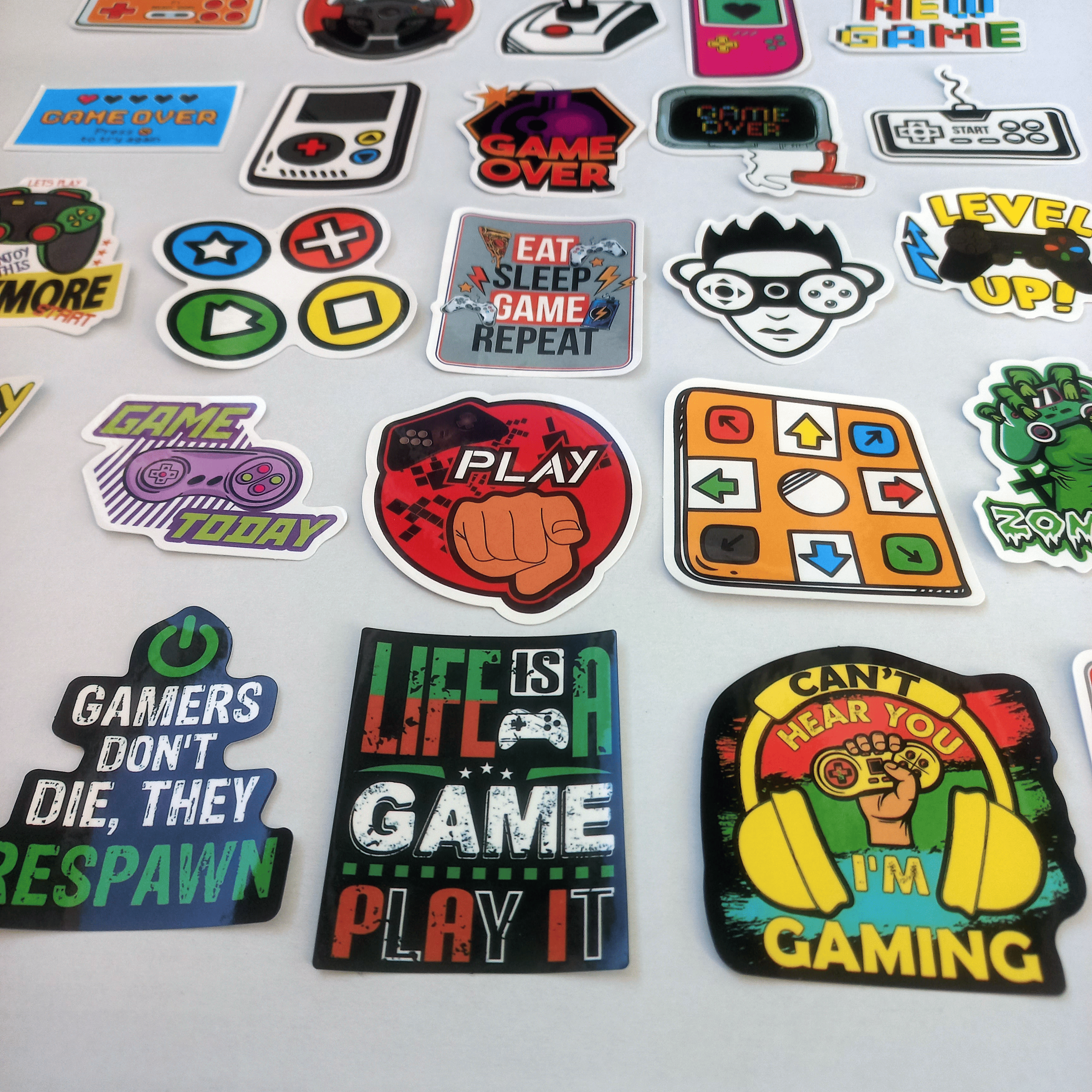 Stickere colorate cu tematică gaming retro – joystick-uri, controlere, personaje și mesaje amuzante pentru gameri.